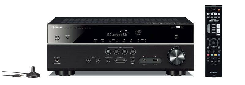 Front face of an AV receiver with a wireless remote on right and the antenna on left.