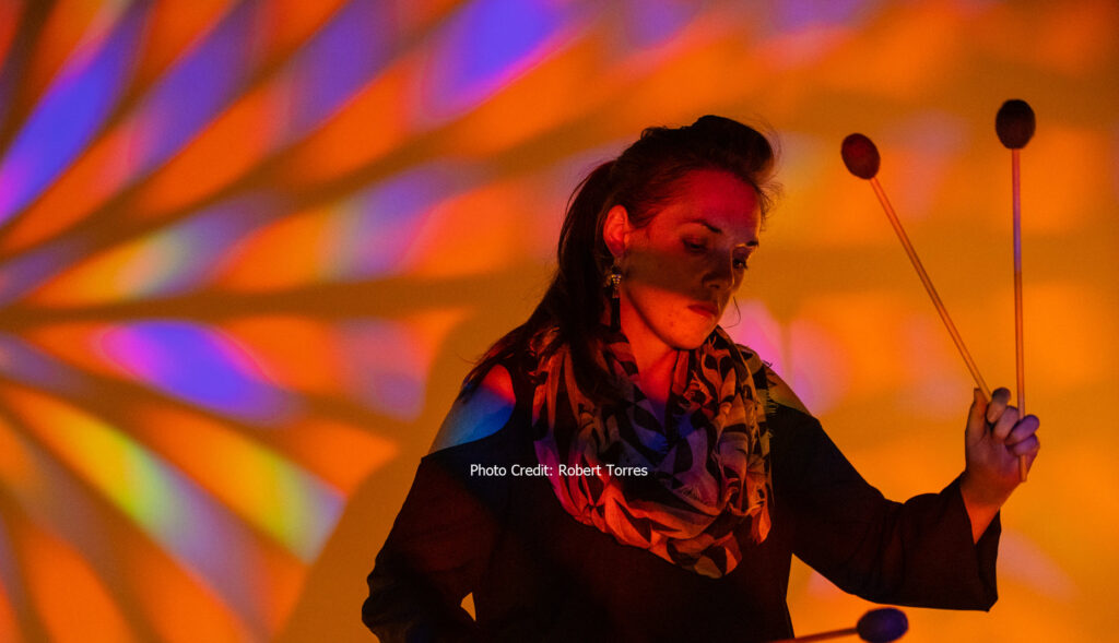 Woman playing the marimbas on stage. Photo credit: Robert Torres.
